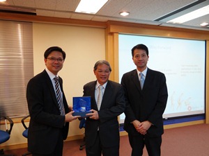 香港測量師學會物業設施管理組增選委員李文光先生(左)與建築測量組理事龐耀寶先生(右)致送紀念品予周幹文先生
 